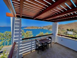 a balcony with a table and a view of the ocean at Litois Houses Patmos in Sapsila