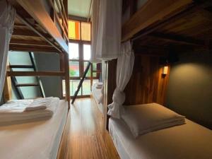 two bunk beds in a room with a window at Bloom Cafe & Hostel in Ko Lipe