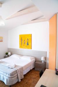 グリゾリーアにあるQueen's Bed & Breakfastのベッドルーム1室(ベッド2台付)が備わります。壁には絵画が飾られています。
