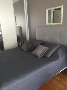 uma cama com duas almofadas num quarto em Lou Suquetan em Cannes