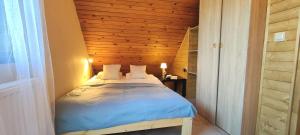 a small bed in a room with a wooden wall at Domek na Porąbkach z kominkiem in Międzybrodzie Żywieckie