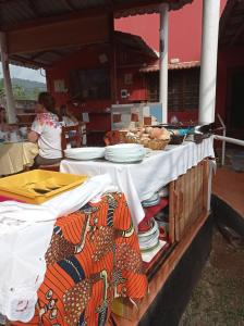 una mesa con platos de comida encima en Residencial Brigada en Santo António