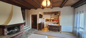a living room with a fireplace and a kitchen at Domek na Porąbkach z kominkiem in Międzybrodzie Żywieckie +24 photos