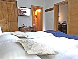 a bedroom with two white beds and a flat screen tv at Green Garden Plitvice lakes in Plitvica selo