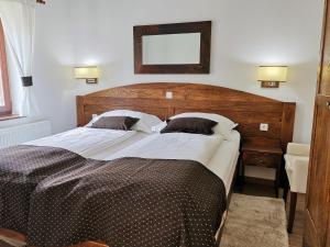 a bedroom with a large bed with a wooden headboard at Green Garden Plitvice lakes in Plitvica selo