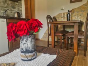a vase filled with red roses on a table at Green Garden Plitvice lakes in Plitvica selo