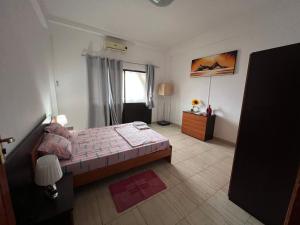 sypialnia z dużym łóżkiem i oknem w obiekcie África em Zona Comercial de Luanda w mieście Luanda