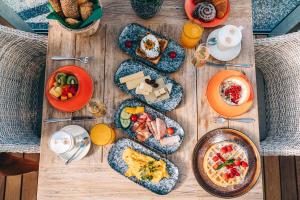 a wooden table topped with breakfast foods and drinks at Loisi's Boutiquehotel in Achenkirch