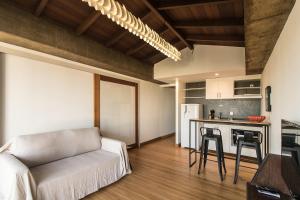 a living room with a couch and a kitchen at Casa Do Gato Cinzento in Rio de Janeiro