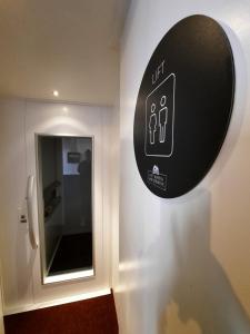 un letrero en la pared de un baño con un urinario en Hotel Het Wapen van Drenthe, en Roden