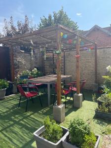 a patio with a table and chairs under a pergola at Vaudes chambre in Vaudes