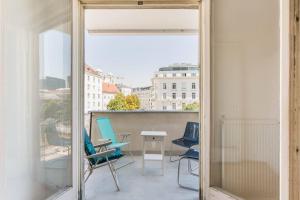 een balkon met stoelen en een tafel bij Studio Stubenbastei in Wenen