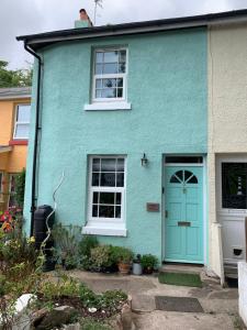 una casa azul con una puerta y ventanas azules en Campion Cottage, en Brixham