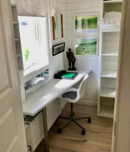 ein Heimbüro mit einem Schreibtisch und Regalen in der Unterkunft Ögränd 2 - Nyrenoverad toppmodern lägenhet in Sveg