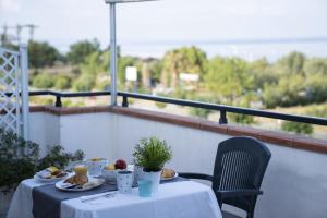 a table with plates of food on a balcony at Queen's Bed & Breakfast in Grisolia
