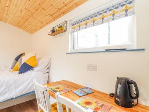 a bedroom with a bed and a table and a window at Sunflower in Redruth