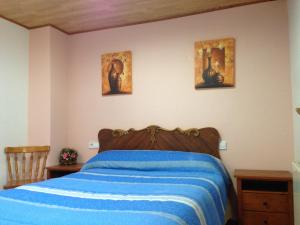 - une chambre avec un lit et trois photos sur le mur dans l'établissement La Ontina, à La Puebla de Valverde