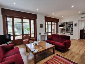 a living room with red couches and a coffee table at Bestouan - 3 Chambres - Clim - Spacieux in Cassis