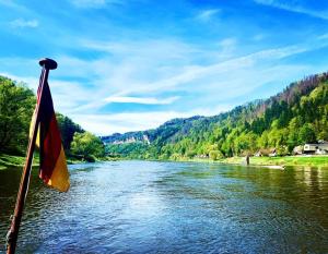 a flag on a boat on a river at Ferienhaus Sandsteinwandblick in Schöna +6 photos