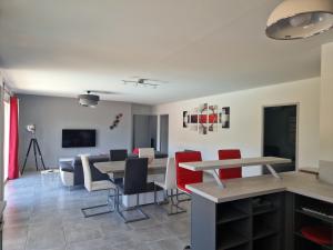 a dining room with tables and red chairs at Les Villas Dorées - Villa Soleil face au Mont Ventoux in Plaisians