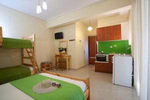 a room with a kitchen and a bed with a hat on it at Jimmy's House in Nikiana