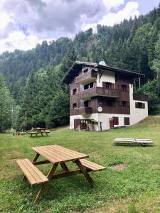 una mesa de picnic en un campo frente a un edificio en Chalet en Haute Savoie Location ski 2 appartements pour 6 ou 8 personnes Saint Gervais Les Bains en Saint-Gervais-les-Bains