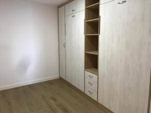 an empty closet with white cabinets and wooden floors at Apartamento vista al puerto de Finisterre II in Fisterra