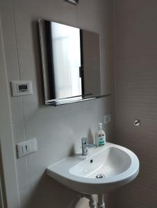 a white bathroom with a sink and a mirror at Trattoria Bar Oasi in Pocenia +25 photos
