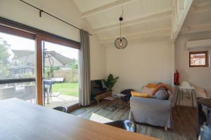 a living room with a large window and a couch at Rustig gelegen chalet Kapeki met tuin aan het water in Geel