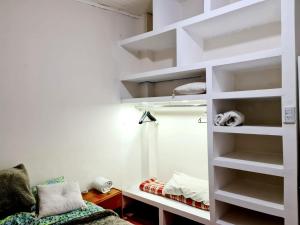 een kamer met witte planken en een bed erin bij H2Otel in Salta