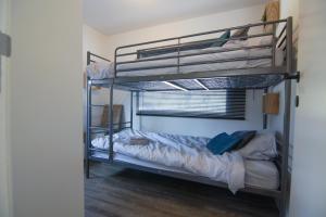 a bedroom with two bunk beds in a room at Rustig gelegen chalet Kapeki met tuin aan het water in Geel