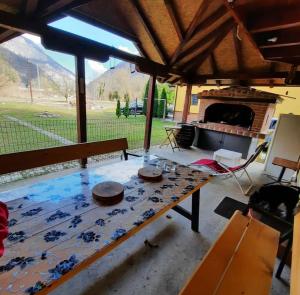 a living room with a table and a fireplace at Vikendica Vila Berbat in Ovčar Banja