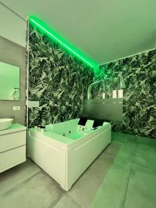 La salle de bains est pourvue d'une grande baignoire et d'une lumière verte. dans l'établissement CA.FOSCARI HARMONY, à Milan