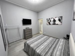 a bedroom with a bed and a flat screen tv at CA FOSCARI HARMONY Jacuzzi Apartment in Milan