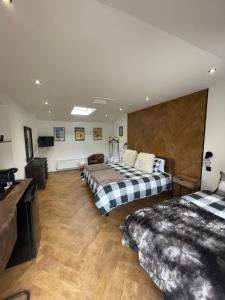 a hotel room with two beds and a television at Golfers dream Guest suite with onsite golf studio available for booking by guests in Strathkinness