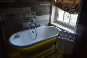 a bath tub in a bathroom with a window at Long Melford Swan in Long Melford