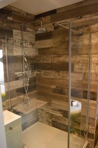 a bathroom with a shower with wooden walls at Long Melford Swan in Long Melford