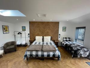 a bedroom with two beds and a chair at Golfers dream Guest suite with onsite golf studio available for booking by guests in Strathkinness