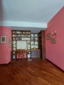 sala de estar con paredes de color rosa y suelo de madera. en Appartamento in pieno centro a Capo d'Orlando, en Capo dʼOrlando