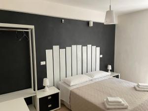 ein Schlafzimmer mit einem großen Bett und einer schwarzen Wand in der Unterkunft Confortevole appartamento a Camigliatello Silano in Camigliatello Silano