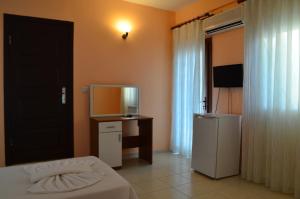 a bedroom with a bed and a desk and a television at Farmside OTEL in Fethiye