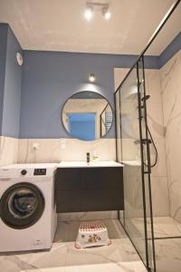 a bathroom with a washing machine and a mirror at Apartamenty Poproszę na Plażę in Jastrzębia Góra