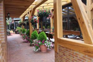 um pátio com vasos de plantas e flores num edifício em Hotel und Pension Am Burchardikloster em Halberstadt