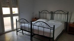 サン・ピエトロ・イン・ベヴァーニャにあるAppartamento San Pietro in Bevagnaのベッドルーム(金属製のベッド、白いシーツ付)