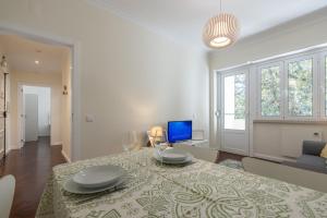 un soggiorno con tavolo e TV di Casa do Largo - cozy apartment in the city center a Lisbona