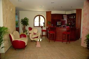 ein Wohnzimmer mit roten und weißen Stühlen und eine Küche in der Unterkunft Agriturismo L'Arca di Anna Brambilla in Belvedere Marittimo