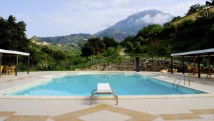 a swimming pool with a chair in front of a mountain at Agriturismo L'Arca di Anna Brambilla in Belvedere Marittimo