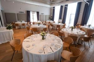 a room full of tables and chairs with white table settings at Casa di Langa in Cerretto Langhe +45 photos
