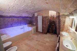 a bathroom with a tub and a toilet and a sink at Tenuta Tresca Suites - Dimora Storica in San Cassiano