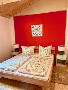 a bedroom with a bed with a red wall at Ferienhaus Blumenwiese in Schöna